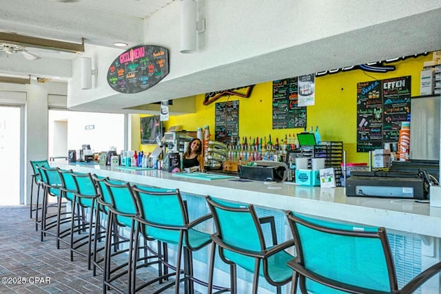 bar with a textured ceiling and ceiling fan