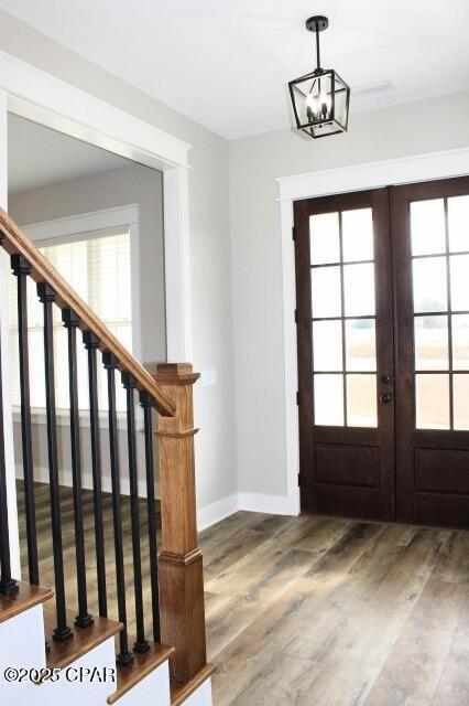 entryway featuring french doors, an inviting chandelier, and hardwood / wood-style floors