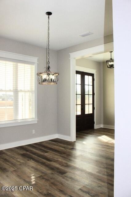 unfurnished dining area featuring dark hardwood / wood-style flooring and french doors