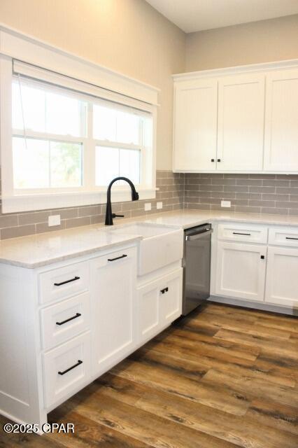 kitchen with white cabinets, stainless steel dishwasher, and dark hardwood / wood-style floors