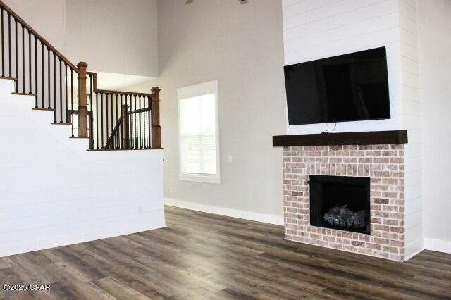 unfurnished living room featuring a fireplace and dark hardwood / wood-style flooring