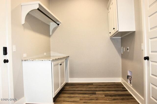 clothes washing area featuring cabinets and dark hardwood / wood-style flooring