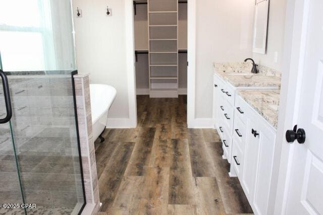 bathroom with hardwood / wood-style floors, independent shower and bath, and vanity