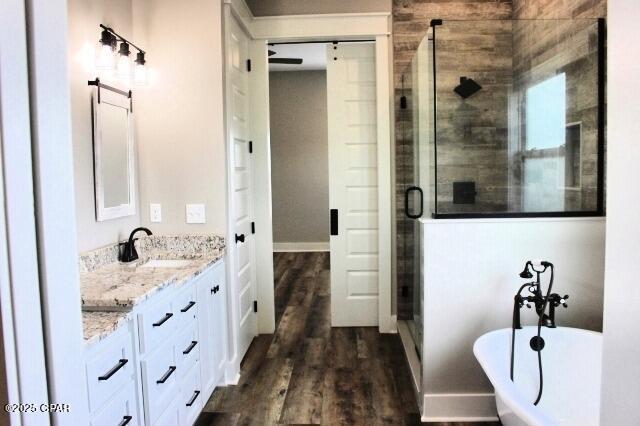 bathroom featuring plus walk in shower, wood-type flooring, and vanity