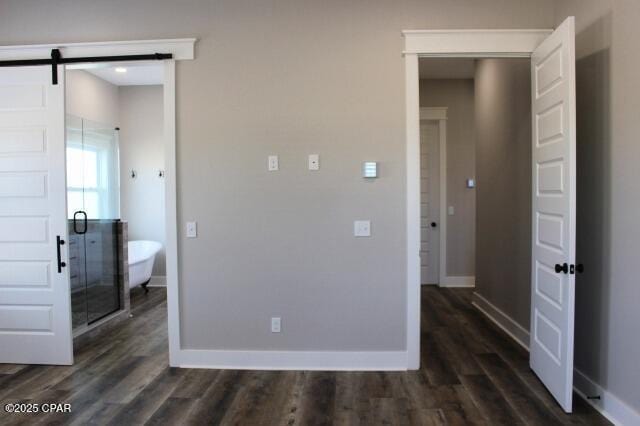 interior space featuring dark hardwood / wood-style flooring and a barn door