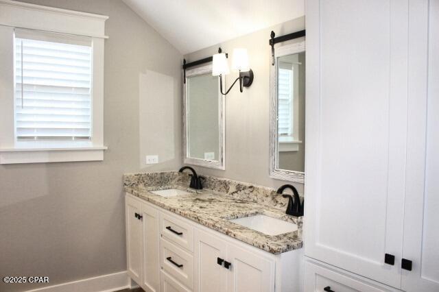 bathroom with lofted ceiling and vanity