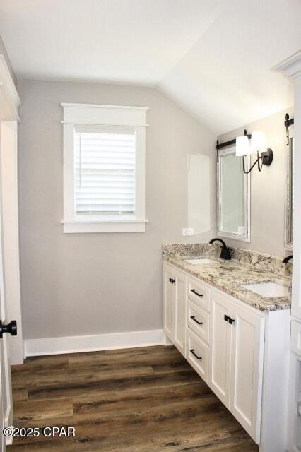 bathroom with lofted ceiling, vanity, and hardwood / wood-style flooring