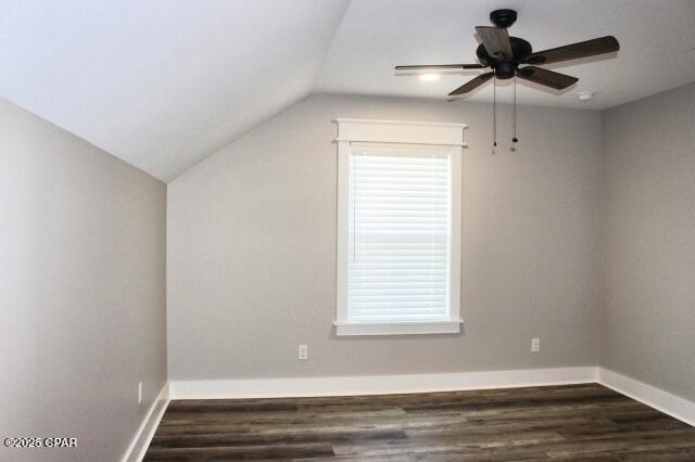 additional living space featuring ceiling fan, dark wood-type flooring, vaulted ceiling, and a wealth of natural light