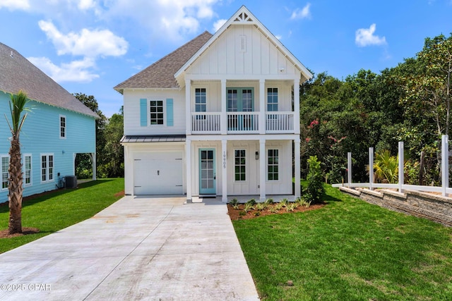 view of front of house with a front yard, cooling unit, a balcony, and a garage