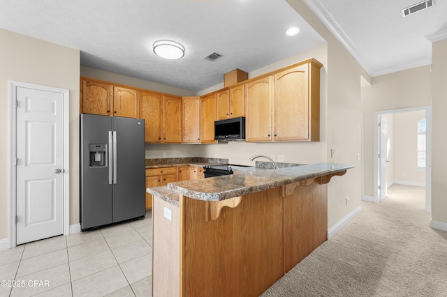 kitchen featuring crown molding, a peninsula, visible vents, and stainless steel fridge with ice dispenser