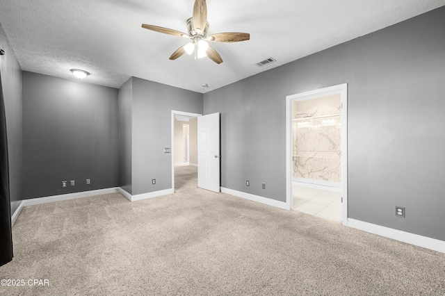 unfurnished bedroom featuring a textured ceiling, carpet floors, visible vents, and baseboards