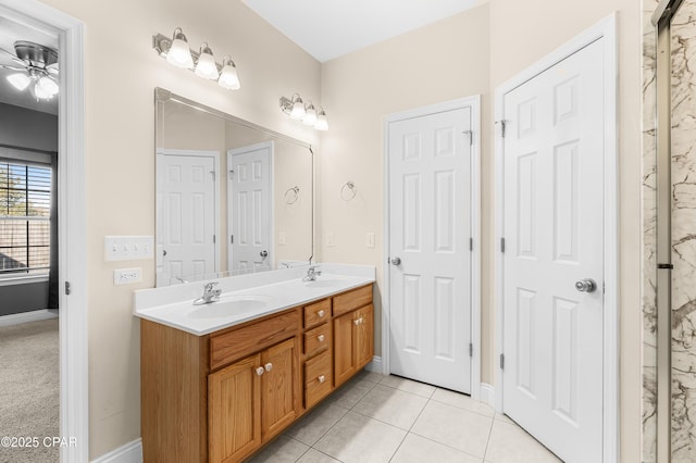 bathroom featuring tile patterned floors, a sink, baseboards, and double vanity