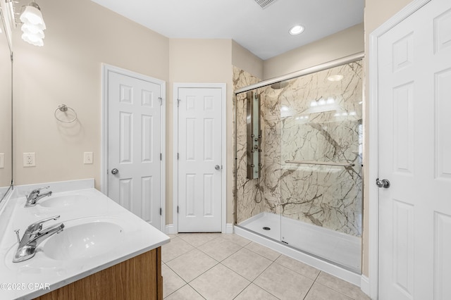 full bathroom with double vanity, tile patterned flooring, a marble finish shower, and a sink