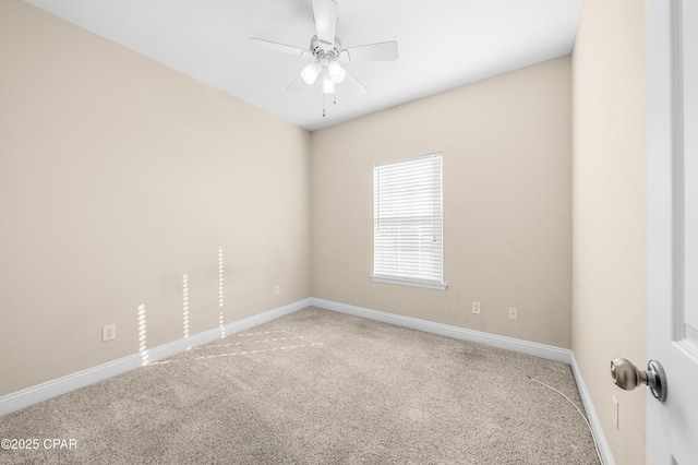 carpeted spare room with ceiling fan and baseboards