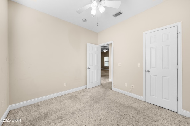 unfurnished bedroom featuring baseboards, visible vents, ceiling fan, and carpet flooring