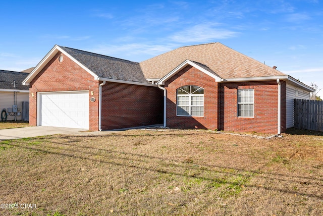 single story home with a shingled roof, concrete driveway, an attached garage, a front lawn, and brick siding