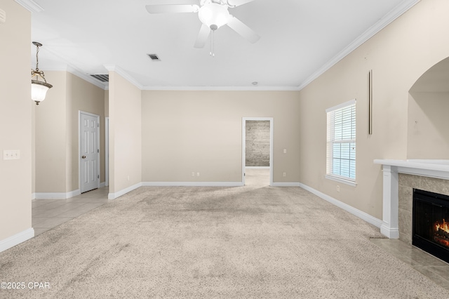 unfurnished living room with a fireplace, visible vents, baseboards, ornamental molding, and carpet