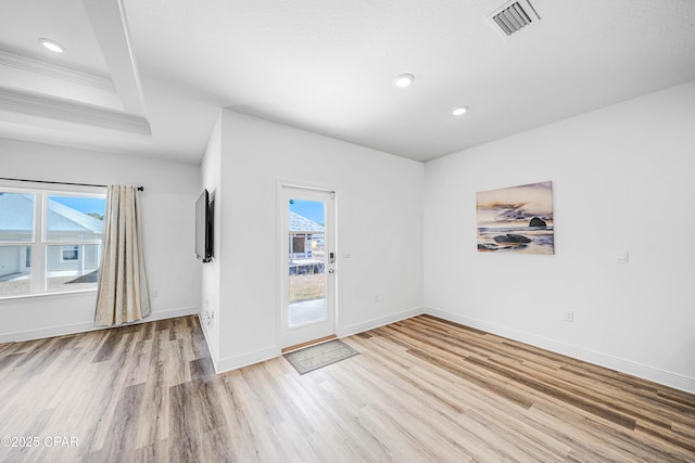 unfurnished room with a tray ceiling and light hardwood / wood-style flooring