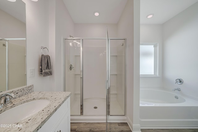 bathroom with vanity, hardwood / wood-style flooring, and independent shower and bath