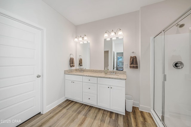 bathroom featuring vanity, wood-type flooring, and walk in shower