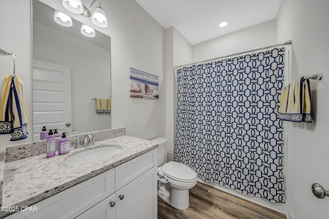 bathroom featuring vanity, hardwood / wood-style floors, toilet, and walk in shower