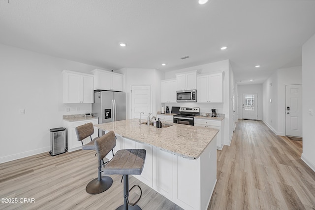 kitchen with white cabinetry, sink, a center island with sink, and appliances with stainless steel finishes