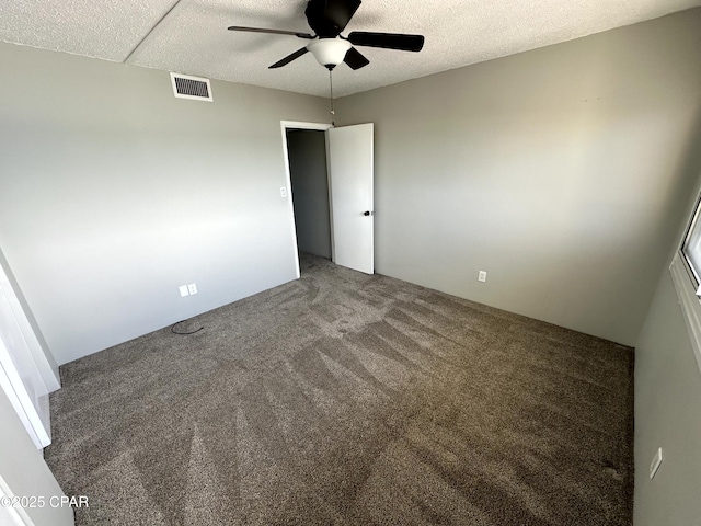 carpeted spare room with a textured ceiling and ceiling fan