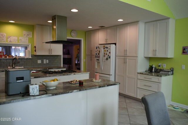 kitchen with a healthy amount of sunlight, island range hood, stainless steel appliances, and white cabinets