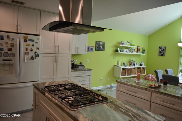 kitchen with white cabinetry, ventilation hood, vaulted ceiling, and light tile patterned floors