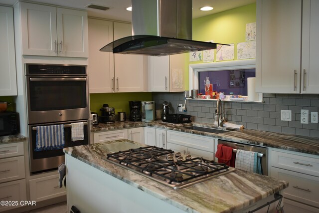 kitchen featuring white cabinetry, sink, stainless steel appliances, and island exhaust hood