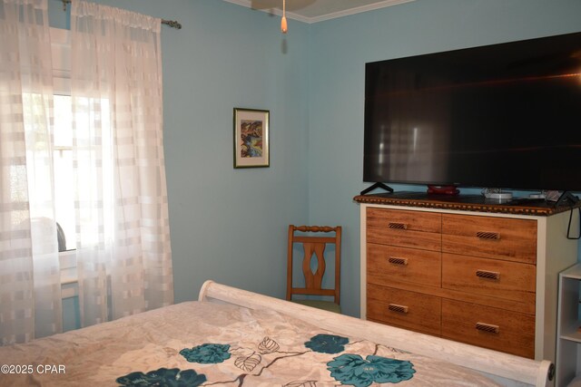 bedroom featuring crown molding, hardwood / wood-style flooring, and ceiling fan