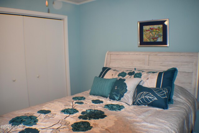 bedroom with wood-type flooring, ornamental molding, and ceiling fan