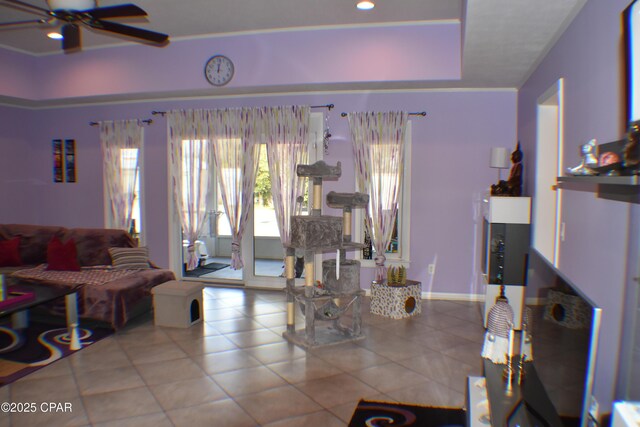 living room with a tray ceiling and ceiling fan