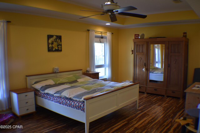 bedroom with ornamental molding, dark wood-type flooring, and ceiling fan