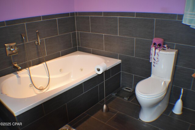 bathroom with a relaxing tiled tub, vanity, tile patterned flooring, and tile walls