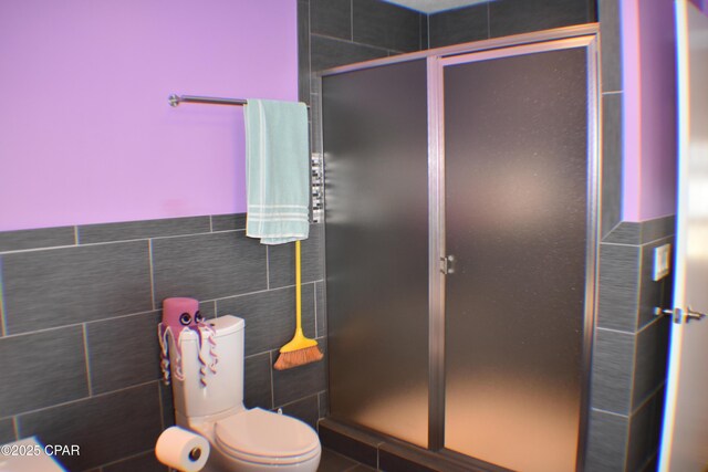 bathroom featuring tile patterned flooring, tiled tub, and toilet