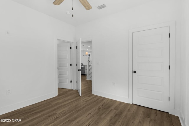 unfurnished bedroom featuring ceiling fan, dark hardwood / wood-style flooring, and a closet