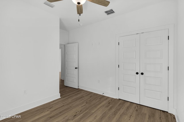 unfurnished bedroom featuring ceiling fan, hardwood / wood-style flooring, and a closet