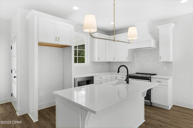 kitchen featuring white cabinetry, a center island with sink, custom range hood, and stainless steel range with electric cooktop