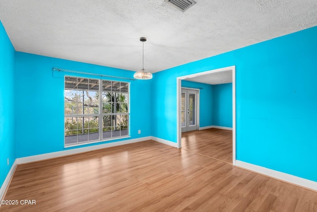 unfurnished dining area featuring wood-type flooring and a textured ceiling