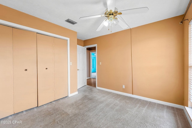 unfurnished bedroom featuring ceiling fan, a closet, and light carpet