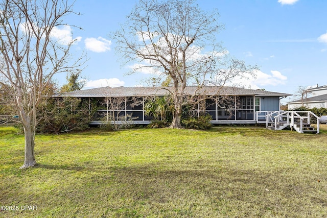 back of property featuring a lawn and a sunroom