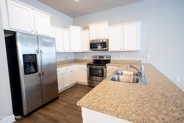 kitchen with dark hardwood / wood-style floors, appliances with stainless steel finishes, white cabinets, and sink