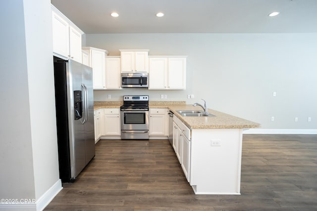 kitchen featuring appliances with stainless steel finishes, kitchen peninsula, sink, and white cabinets