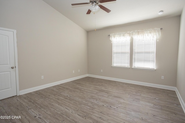 empty room with hardwood / wood-style flooring, vaulted ceiling, and ceiling fan