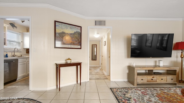 living room with crown molding, light tile patterned flooring, sink, and wood walls