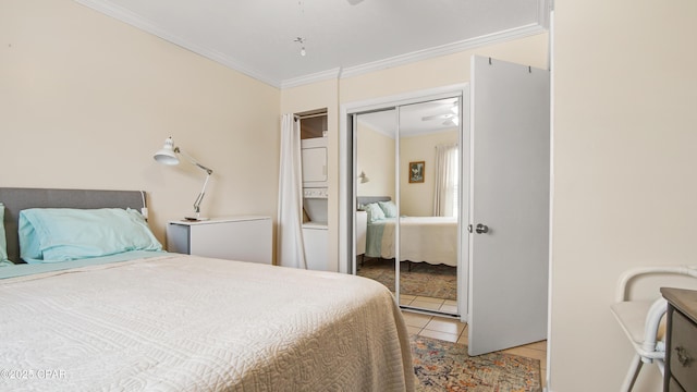 bedroom featuring light tile patterned flooring, crown molding, and a closet