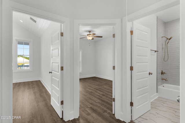 hallway with vaulted ceiling and hardwood / wood-style floors