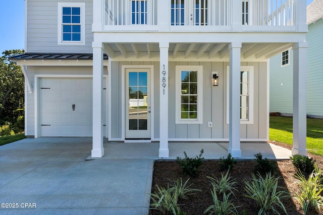 property entrance with a garage, a porch, and a balcony