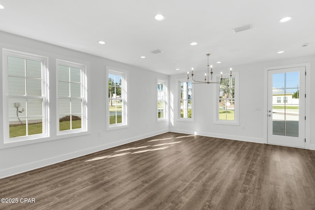 unfurnished dining area featuring dark hardwood / wood-style floors and a chandelier